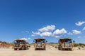 Three large dumper trucks in a row.