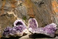 Three large purple crystals are sitting on a rock Royalty Free Stock Photo