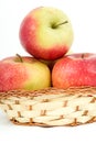 Three large ripe red apples in a wicker basket Royalty Free Stock Photo