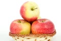 Three large ripe red apples in a wicker basket Royalty Free Stock Photo
