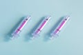 Three large vaccination syringes together with the needle uncapped on a textured blue paper background. Royalty Free Stock Photo