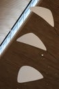 White mobile blades against light brown wood slat ceiling with pinprick can lights and square windows Royalty Free Stock Photo