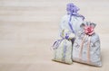 Three lavender scent pouches on wooden board or table. Scented sachets on wood with copy space. Fragrance bags for fresh home. Royalty Free Stock Photo