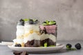Three layered desserts with vanilla and chocolate cake, whipped cream and blackberries Royalty Free Stock Photo