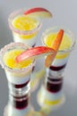 Three layered shot drink based on liqueur, cream and apple peach juice, decorated with colored sugar and a slice of apple Royalty Free Stock Photo