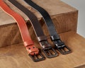 Three leather belts of different colors displayed on wooden stand Royalty Free Stock Photo