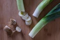 Three leeks partially chopped on a rustic cutting board