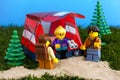 Three Lego tourist minifigures near their tent outdoors