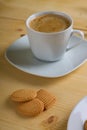 Three lemon biscuits in front of creamy coffee