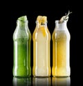 Three lemonade with lemon, kiwi, apple, cucumber, rosemary and mint in glass bottles isolated on black background. Summer cold Royalty Free Stock Photo