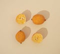 Three lemons partially dried on a pastel beige background arranged in a square shape. Flat lay design. Colorful citrus fruit.