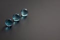 Three light blue crystal glass balls showing reflections on a matt black surface - stock photo.jpg Royalty Free Stock Photo