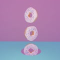 Three light donuts vertically in antigravity on a pink-blue background 3d illustration