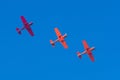 Three light-engine turboprop red aircraft fly in formation in a straight line in the sky