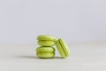 Three light green french macarons on a wooden table. Pistachio macarons