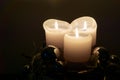 Lighted white candles and shiny blue silver Christmas baubles decoration on dark background