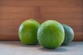 Three limes closeup on a wooden background.