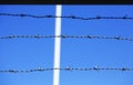 Three lines of barbed wire against a blue background