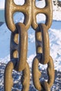 Three links of iron chains in the seaport hang against the background of snow Royalty Free Stock Photo