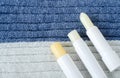 Three lip balms on the knitted background. Winter lip care sticks with beeswax, honey, panthenol and shea butter.