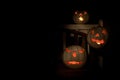 Three lit white jack o-lanterns on a bench