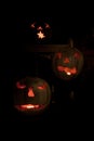 Three lit white jack o-lanterns on a bench