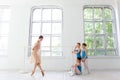 Three little ballerinas dancing with personal ballet teacher in dance studio Royalty Free Stock Photo