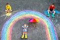Three little children, two school kids boys and toddler girl having fun with with rainbow picture drawing with colorful Royalty Free Stock Photo