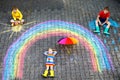 Three little children, two school kids boys and toddler girl having fun with with rainbow picture drawing with colorful Royalty Free Stock Photo