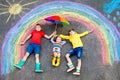 Three little children, two school kids boys and toddler girl having fun with with rainbow picture drawing with colorful Royalty Free Stock Photo