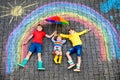 Three little children, two school kids boys and toddler girl having fun with with rainbow picture drawing with colorful Royalty Free Stock Photo