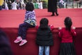 Three little girls leaning on the edge of the stage, absorbed in the performance Royalty Free Stock Photo