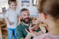 Three little girls putting on make up on their father, fathers day with daughters at home.