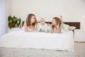 Three little girls sisters play in the bedroom on the bed Royalty Free Stock Photo