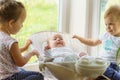 Three little Kids play near the window. Brothers and sister with the baby.Toddler kid meeting newborn sibling. Children