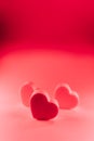 Three little pink hearts of sponge situated together on a pink background with a red lighting. San Valentine`s day backgrounds