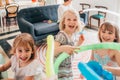 Three little sisters indoor at home playing with balloon having fun smiling Royalty Free Stock Photo