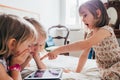 Three little sisters indoor at home using tablet lying in bed Royalty Free Stock Photo