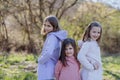 Three little sisters looking at camera in spring nature together. Royalty Free Stock Photo