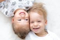 Three Little smiling kids play together on bed. Happy Brother and sister show emotions. Twins have fun at home on soft Royalty Free Stock Photo