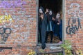 Three little teenage girls in zombie costumes go out the door of an old ruined building and look frighteningly at the camera. Royalty Free Stock Photo