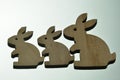 Three wooden Easter bunnies on a glass table