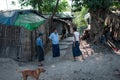 Three local burmese men in longyi having a conversation outside Yangon, Myanmar