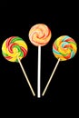 Three of Lollipop round shape. Isolated on black background. Multi-colored caramel candies