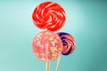 Three lollipops on blue green background Royalty Free Stock Photo
