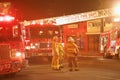 Los Angeles Fire Department firemen next to fire trucks