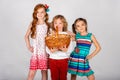 Three lovely children on a white background, the boy is holding a basket with