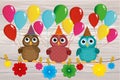 Three lovely owls sit on a rope and hold balloons. Hanging on cl Royalty Free Stock Photo