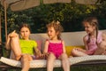 Three lovely sisters on soft garden swing Royalty Free Stock Photo