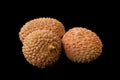 Three lychee fruits isolated on a black background